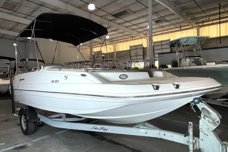 Slide: The Image of 2022 Hurricane SunDeck Sport 201 OB boat on trailer, featuring a black canopy. - 5