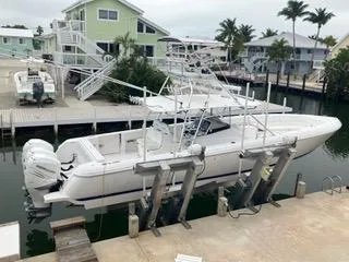 Slide: The Image of 2016 Intrepid 400 Center Console boat docked in a marina with waterfront homes. - 0