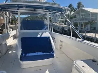 Slide: The Image of 2016 Intrepid 400 Center Console boat with blue seating, docked near waterfront homes. - 14