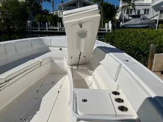Slide: The Image of 2016 Intrepid 400 Center Console boat with open storage compartment, docked near waterfront homes. - 20