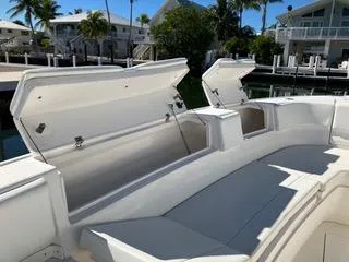Slide: The Image of 2016 Intrepid 400 Center Console boat with open storage compartments, docked near waterfront homes. - 28