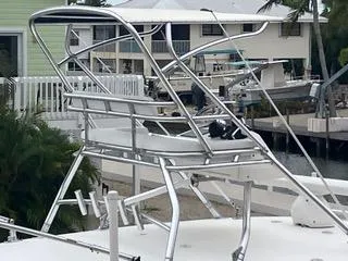 Slide: The Image of 2016 Intrepid 400 Center Console boat with sleek metal framework, docked near waterfront homes. - 30