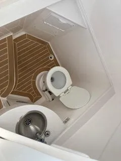Slide: The Image of 2019 Intrepid 400 Center Console boat bathroom with toilet and sink. - 4