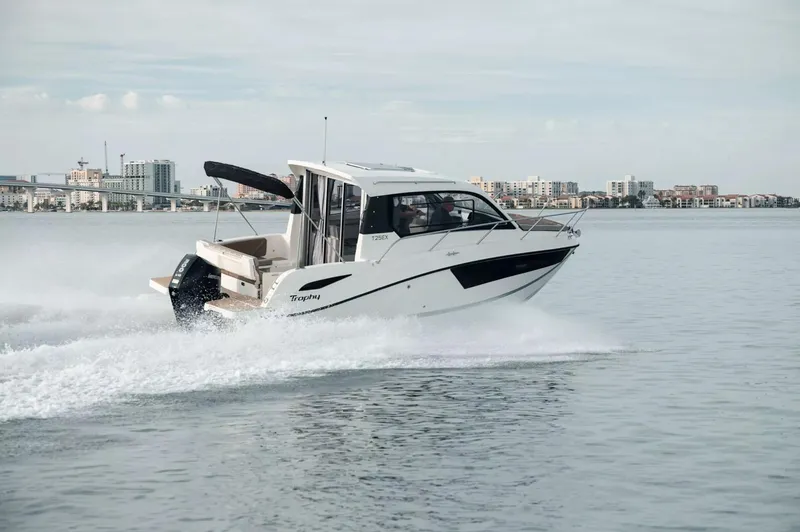 Slide: The Image of 2025 Bayliner TROPHY 25 EXPLORER cruising on calm water near city skyline. - 1