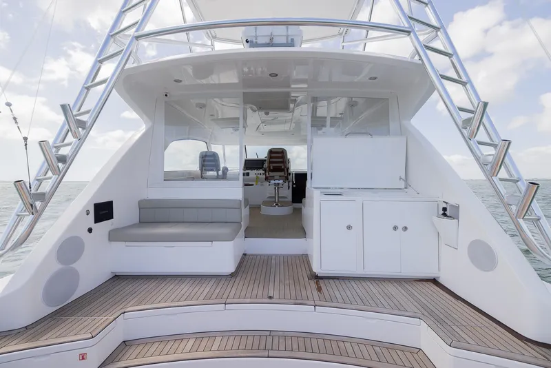 Slide: The Image of 2022 Bertram 50 yacht deck with seating and cabinetry, featuring sleek design and ocean backdrop. - 14