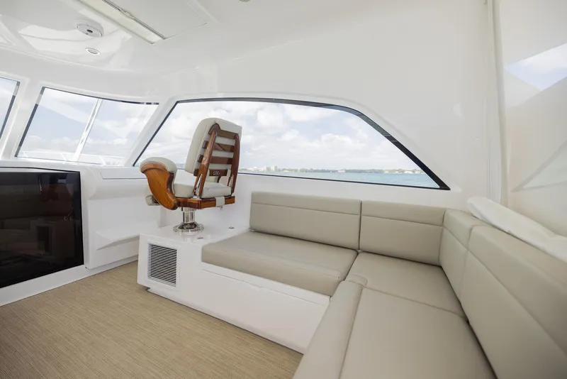 Slide: The Image of Luxurious interior of a 2022 Bertram 50 yacht with plush seating and panoramic windows. - 16