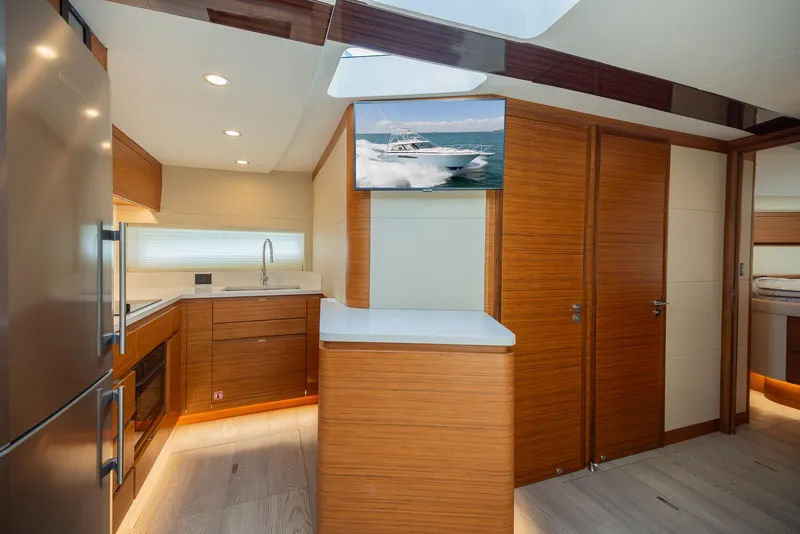Slide: The Image of Modern kitchen interior of 2022 Bertram 50 yacht with wood finishes and stainless steel appliances. - 22