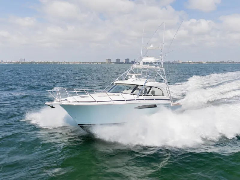 Slide: The Image of 2022 Bertram 50 yacht cruising swiftly on open water under a partly cloudy sky. - 4