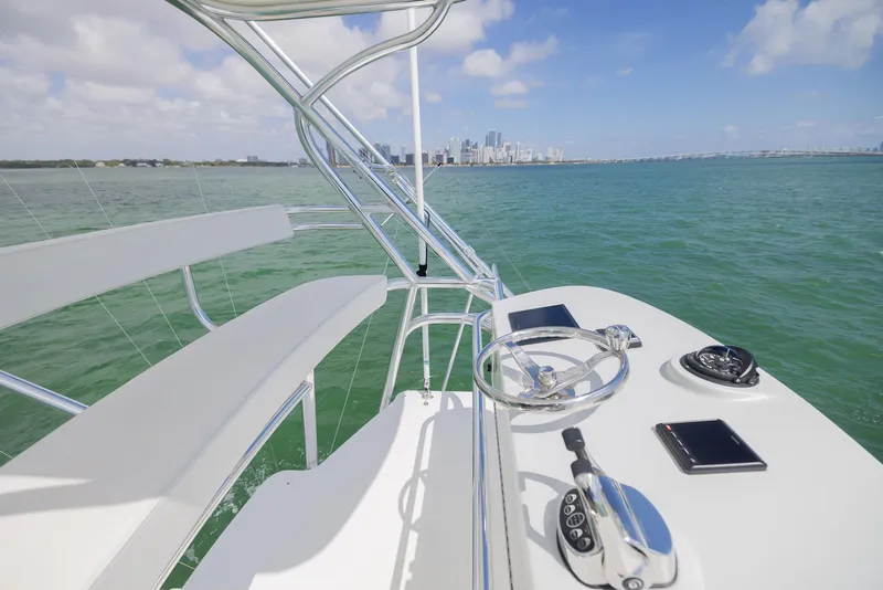 Slide: The Image of 2022 Bertram 50 yacht helm with ocean view and city skyline in the background. - 8