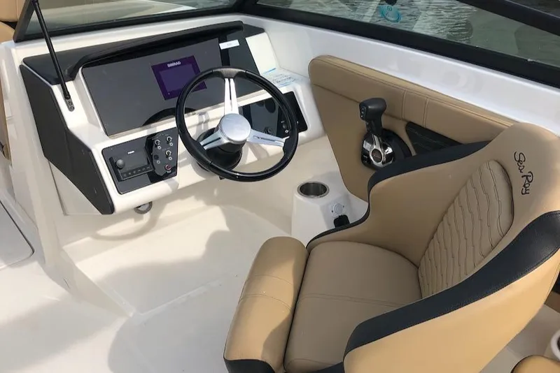 Slide: The Image of 2022 Sea Ray SPX 230 OB boat cockpit with steering wheel and beige seating. - 13