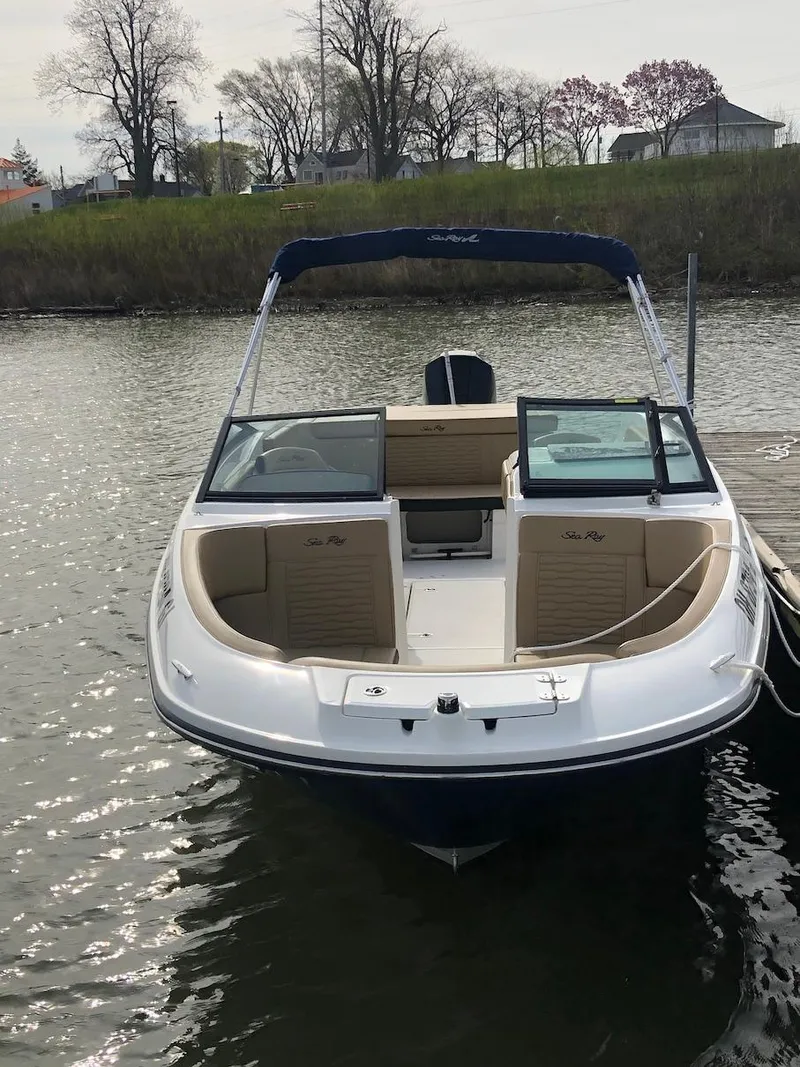 Slide: The Image of 2022 Sea Ray SPX 230 OB boat docked on calm water, featuring open bow seating. - 2