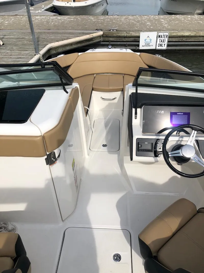 Slide: The Image of 2022 Sea Ray SPX 230 OB boat interior with tan seating and modern dashboard. - 7