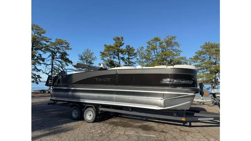 Slide: The Image of 2025 Tahoe Pontoon Cascade Cruise Rear Bench on trailer, parked outdoors. - 2