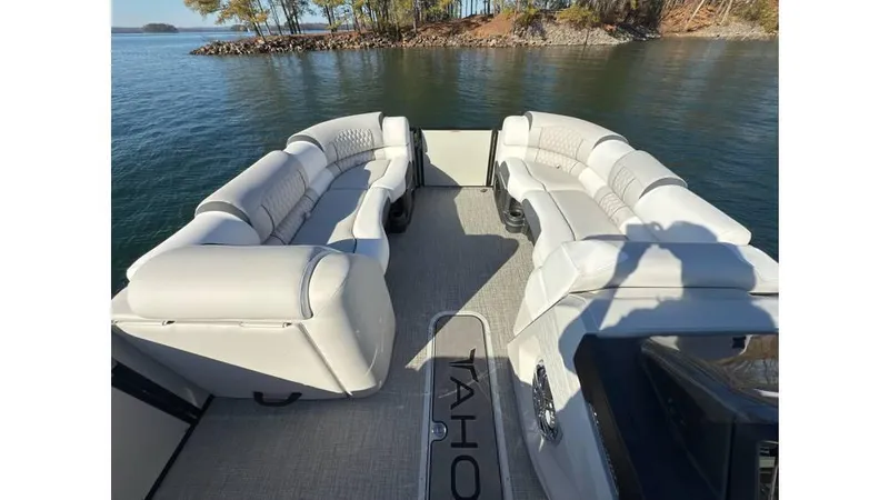 Slide: The Image of 2025 Tahoe Pontoon Cascade Cruise Rear Bench on serene lake with plush seating. - 8