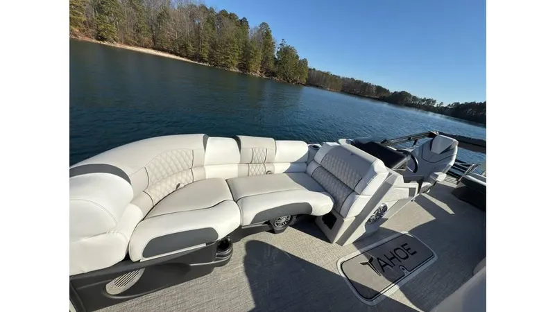 Slide: The Image of 2025 Tahoe Pontoon Cascade Cruise Rear Bench on serene lake with plush seating. - 9