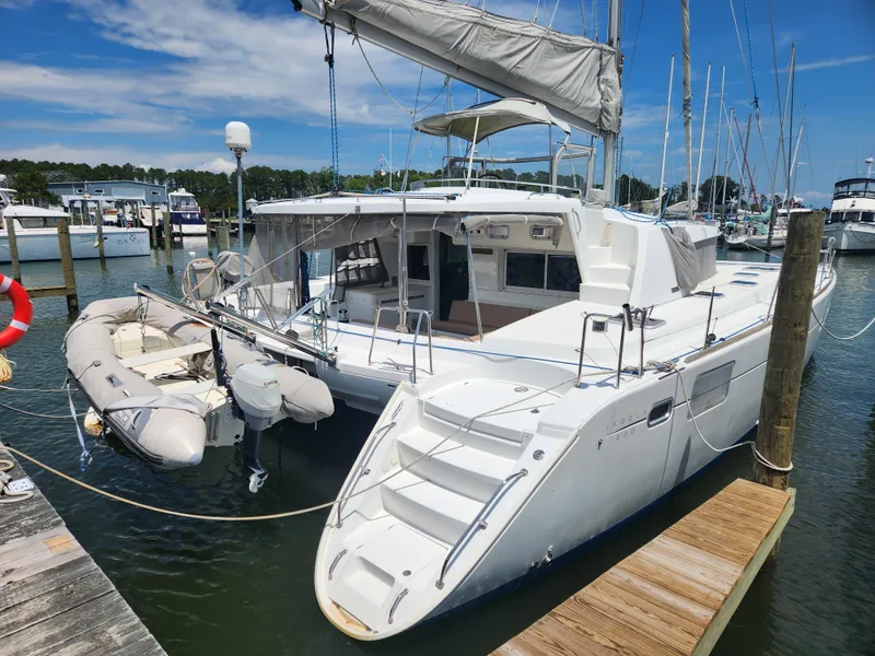 The Image of 2006 Lagoon 440 catamaran docked at marina with inflatable dinghy attached. - 1
