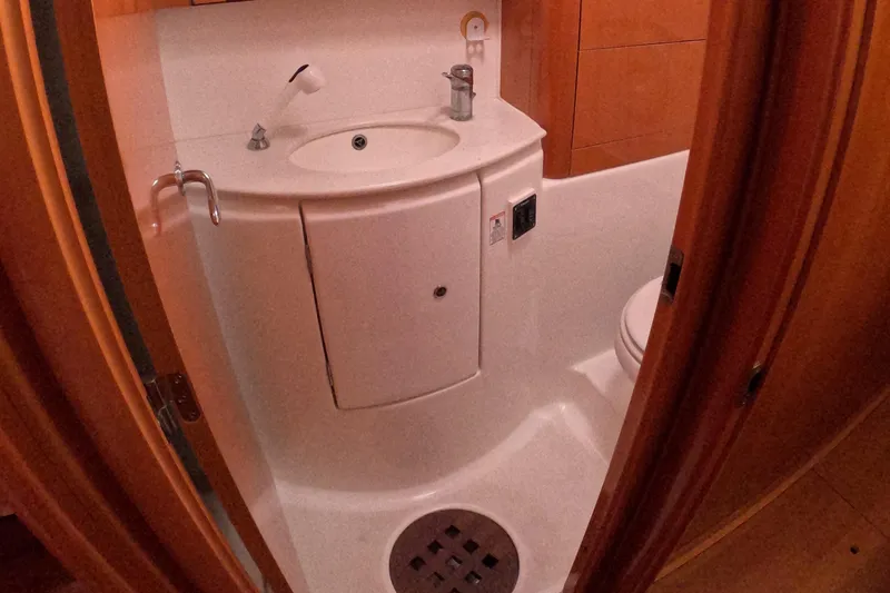 Slide: The Image of Compact bathroom in a 2006 Lagoon 440 yacht, featuring a sink and toilet. - 15