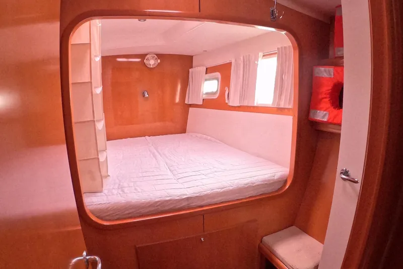 Slide: The Image of Cozy cabin interior of 2006 Lagoon 440 catamaran with bed and porthole windows. - 20