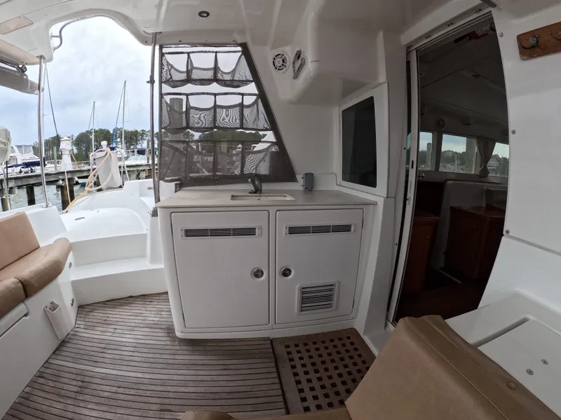 Slide: The Image of 2006 Lagoon 440 yacht interior with seating, cabinetry, and open door to cabin. - 24
