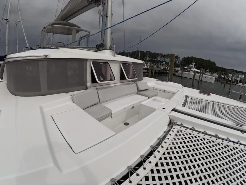 Slide: The Image of Lagoon 440 catamaran, 2006 model, docked with spacious deck and netting, under cloudy skies. - 27