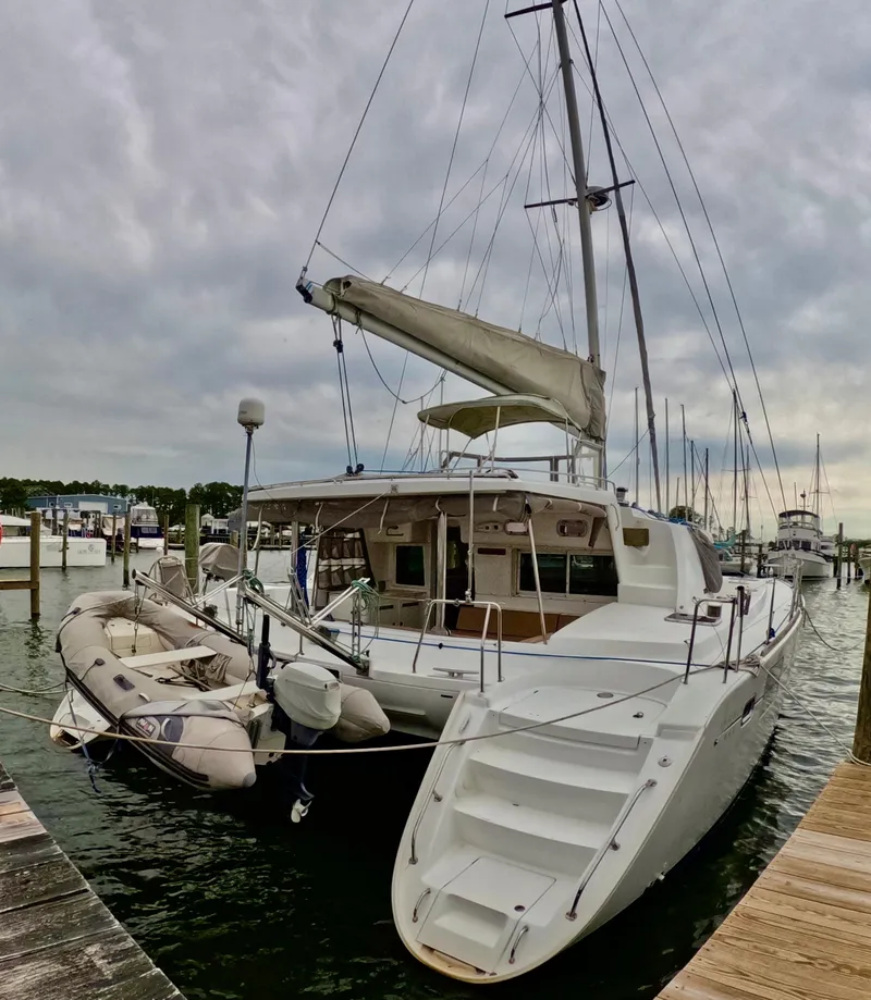 Slide: The Image of 2006 Lagoon 440 catamaran docked at marina with inflatable dinghy attached. - 30
