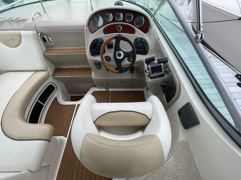 Slide: The Image of 2008 Sea Ray 280 Sundancer helm with wood accents and beige seating. - 11