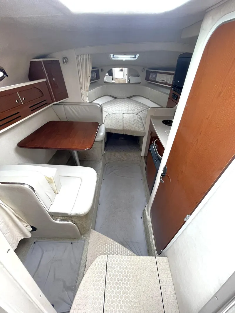 Slide: The Image of 2008 Sea Ray 280 Sundancer cabin interior with dining area, bed, and kitchenette. - 14