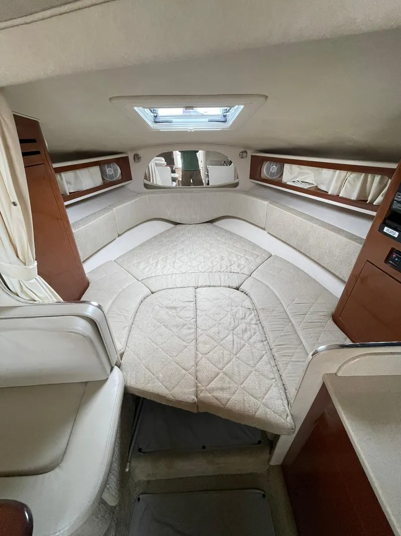 Slide: The Image of 2008 Sea Ray 280 Sundancer cabin interior with beige upholstery and wood accents. - 15