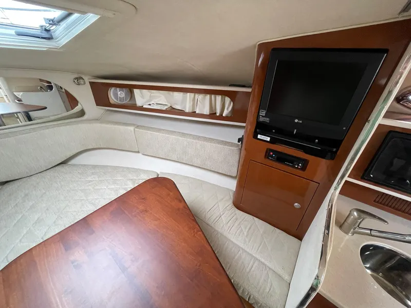 Slide: The Image of 2008 Sea Ray 280 Sundancer cabin interior with TV, seating, and wooden table. - 17
