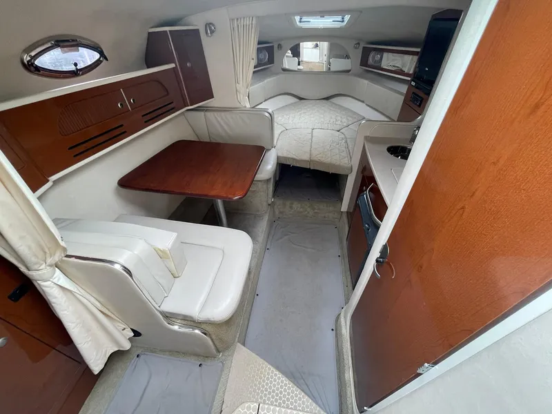 Slide: The Image of 2008 Sea Ray 280 Sundancer cabin interior with dining area and sleeping quarters. - 18