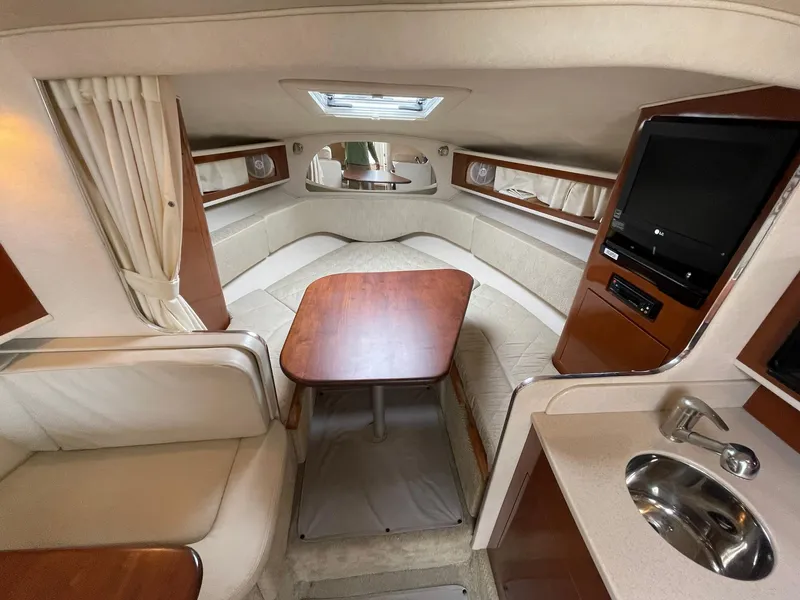 Slide: The Image of Interior of 2008 Sea Ray 280 Sundancer with seating, table, and kitchenette. - 22