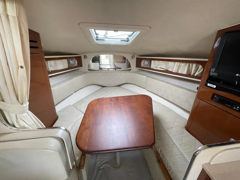 Slide: The Image of 2008 Sea Ray 280 Sundancer cabin interior with wood table and seating. - 23