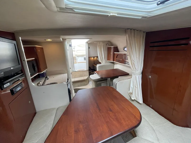 Slide: The Image of Interior of 2008 Sea Ray 280 Sundancer with wood table, seating, and kitchenette. - 24