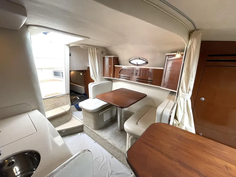 Slide: The Image of Interior of 2008 Sea Ray 280 Sundancer, featuring cozy seating and wooden tables. - 26
