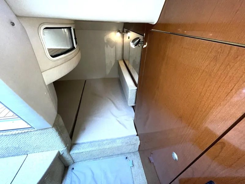 Slide: The Image of 2008 Sea Ray 280 Sundancer cabin interior with wood paneling and compact sleeping area. - 28