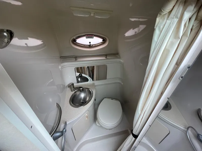 Slide: The Image of Compact bathroom in 2008 Sea Ray 280 Sundancer boat with sink, toilet, and shower curtain. - 30