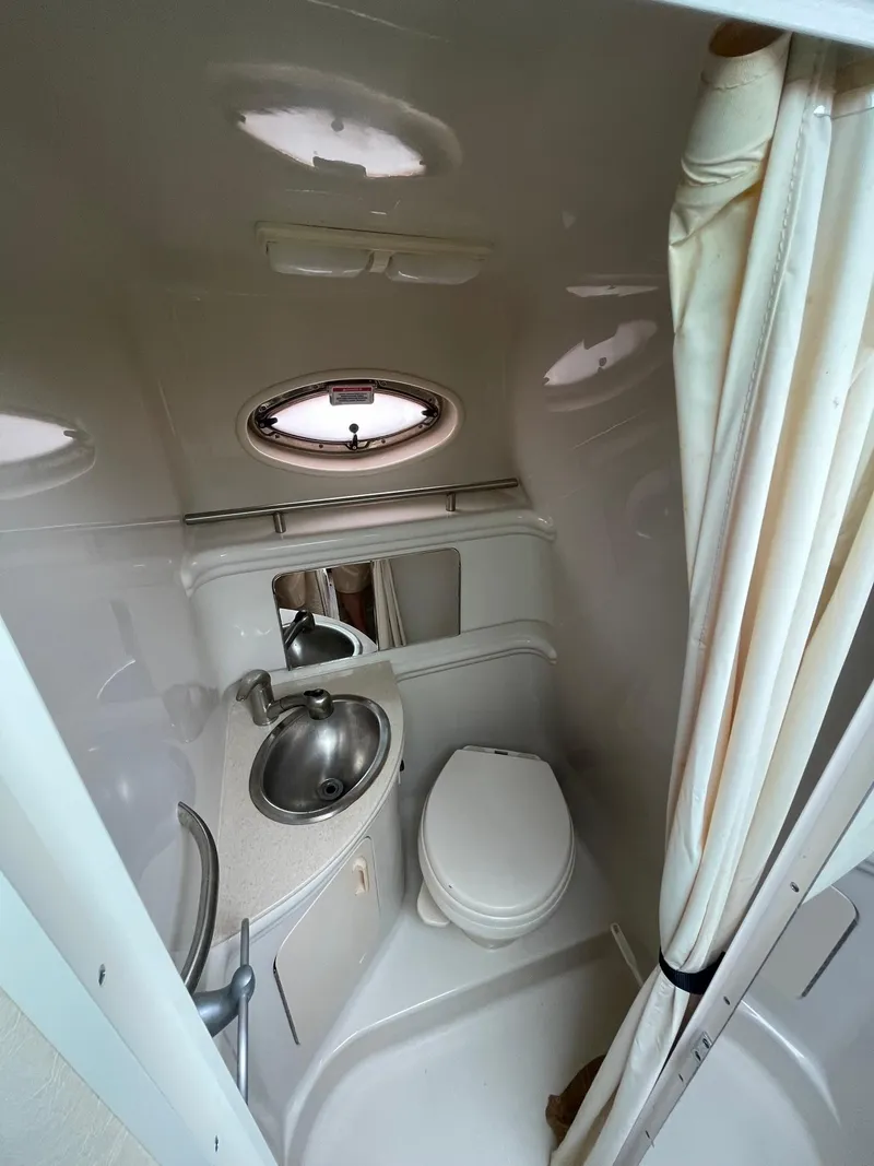Slide: The Image of 2008 Sea Ray 280 Sundancer bathroom with sink, toilet, and porthole window. - 31