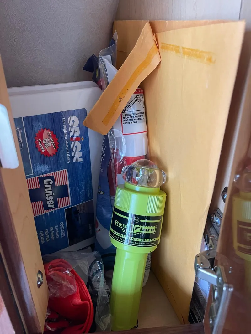 Slide: The Image of Storage compartment on a 2008 Sea Ray 280 Sundancer with safety equipment and documents. - 36