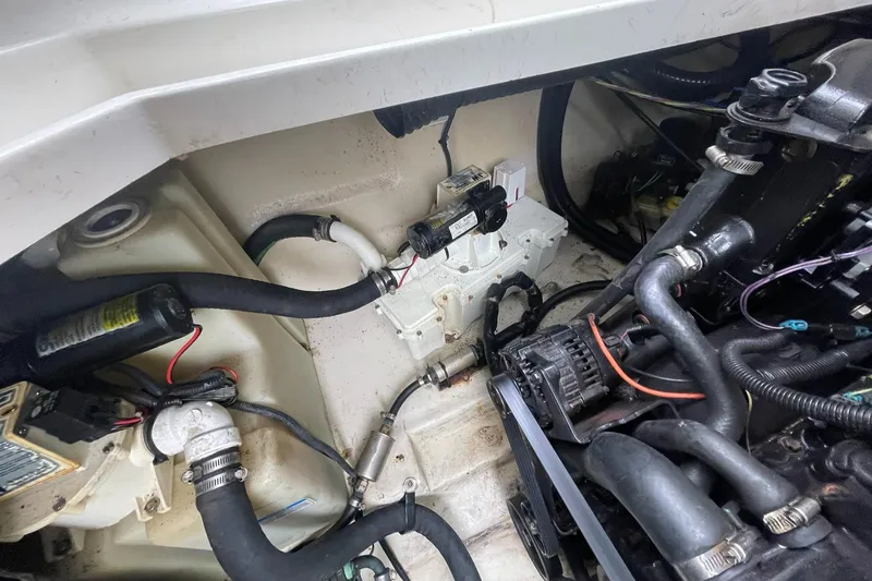 Slide: The Image of Engine compartment of a 2008 Sea Ray 280 Sundancer boat, showing hoses and mechanical components. - 49