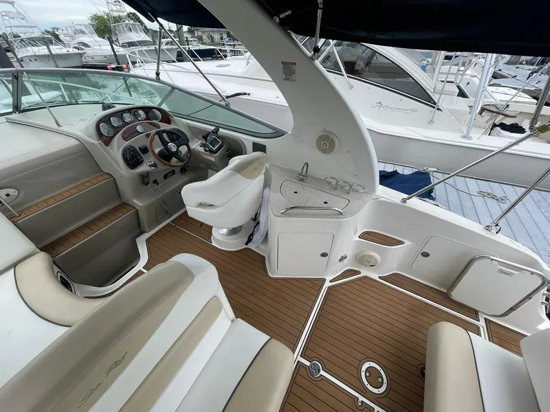 Slide: The Image of 2008 Sea Ray 280 Sundancer boat interior with helm, seating, and wood flooring. - 9