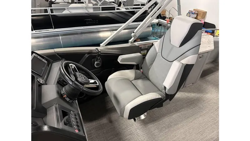 Slide: The Image of 2025 Tahoe Pontoon Cascade Cruise Rear Bench captain's chair and helm, featuring modern controls. - 25