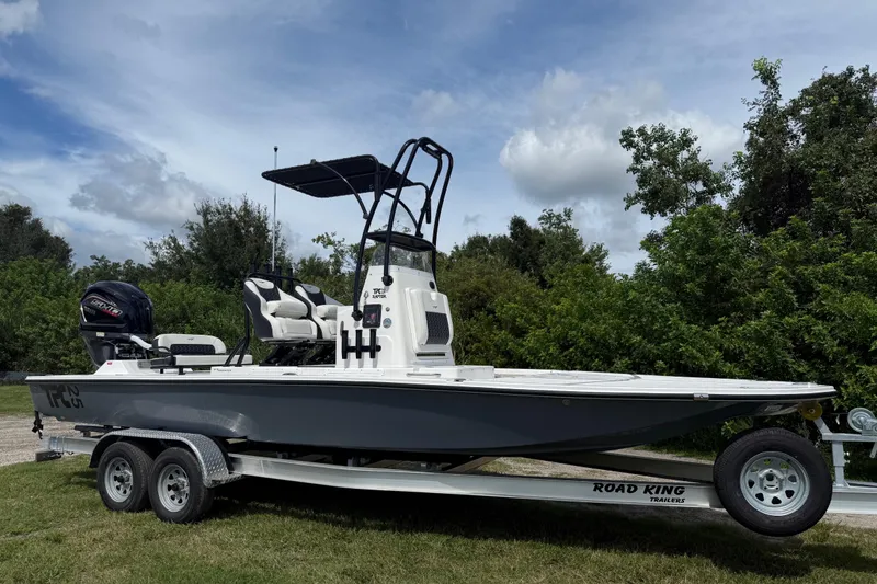 Slide: The Image of 2025 Tidewater 25 TPC Raptor boat on trailer, parked outdoors under cloudy sky. - 10
