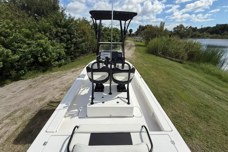 Slide: The Image of 2025 Tidewater 25 TPC Raptor boat on grassy shore near water and trees. - 14