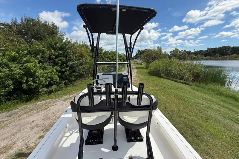 Slide: The Image of 2025 Tidewater 25 TPC Raptor boat on grassy shore, under blue sky. - 15