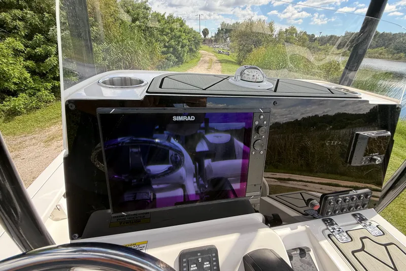 Slide: The Image of 2025 Tidewater 25 TPC Raptor boat dashboard with Simrad display and compass. - 18