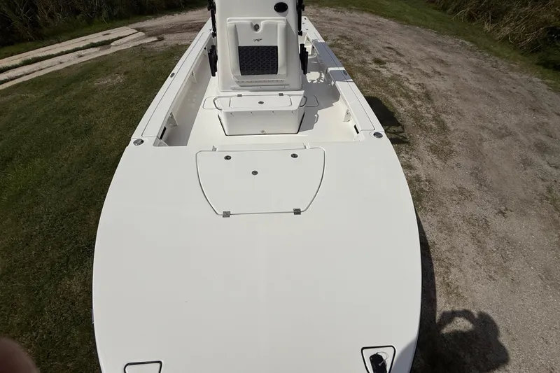 Slide: The Image of 2025 Tidewater 25 TPC Raptor boat deck, white finish, parked on grassy area. - 20