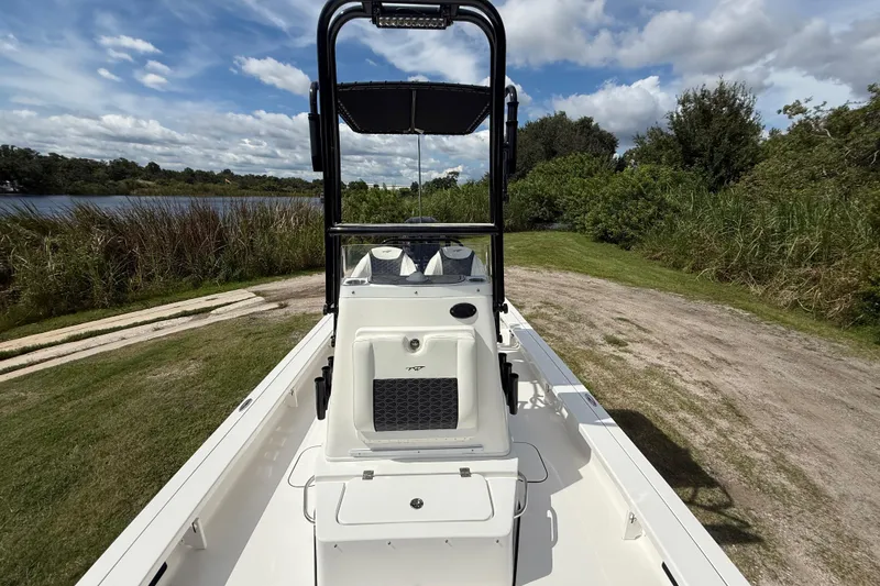 Slide: The Image of 2025 Tidewater 25 TPC Raptor boat on grassy shore, under a partly cloudy sky. - 22