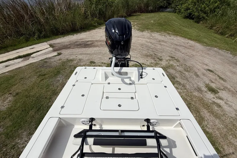 Slide: The Image of 2025 Tidewater 25 TPC Raptor boat with outboard motor, parked on grassy terrain. - 27