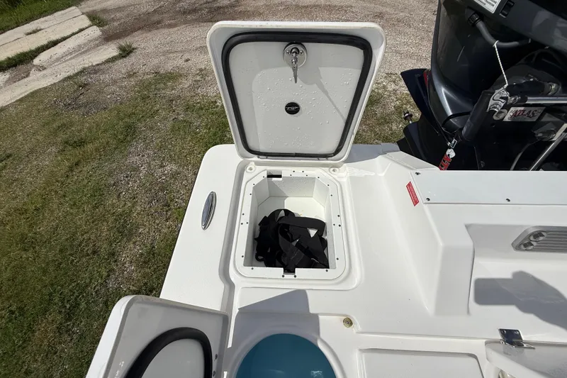 Slide: The Image of 2025 Tidewater 25 TPC Raptor boat storage compartment with open hatch and visible engine. - 30