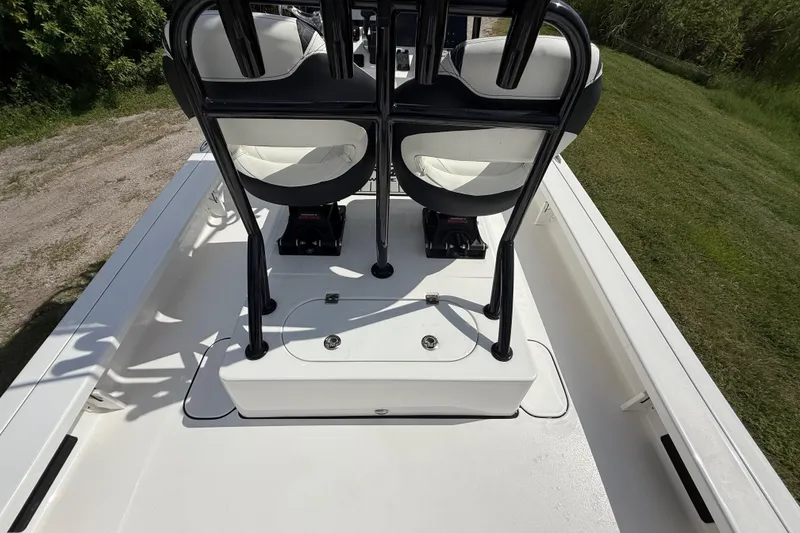 Slide: The Image of 2025 Tidewater 25 TPC Raptor boat interior with seating and storage on a grassy area. - 35